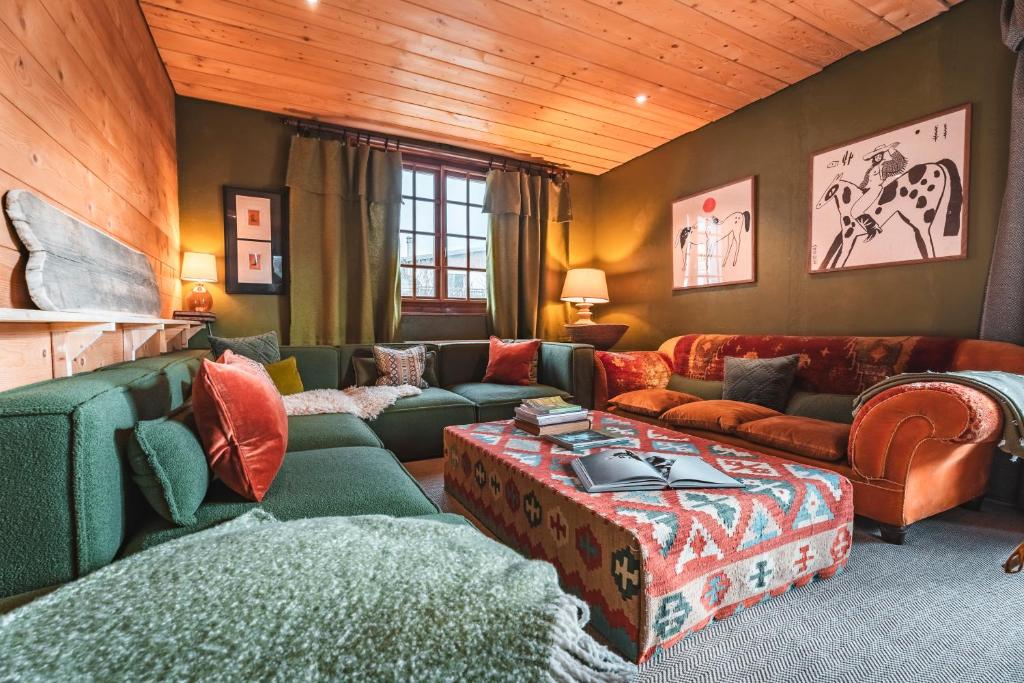 sala de estar con sofá y mesa en The Fat Fox Lodge, Morzine, en Montriond