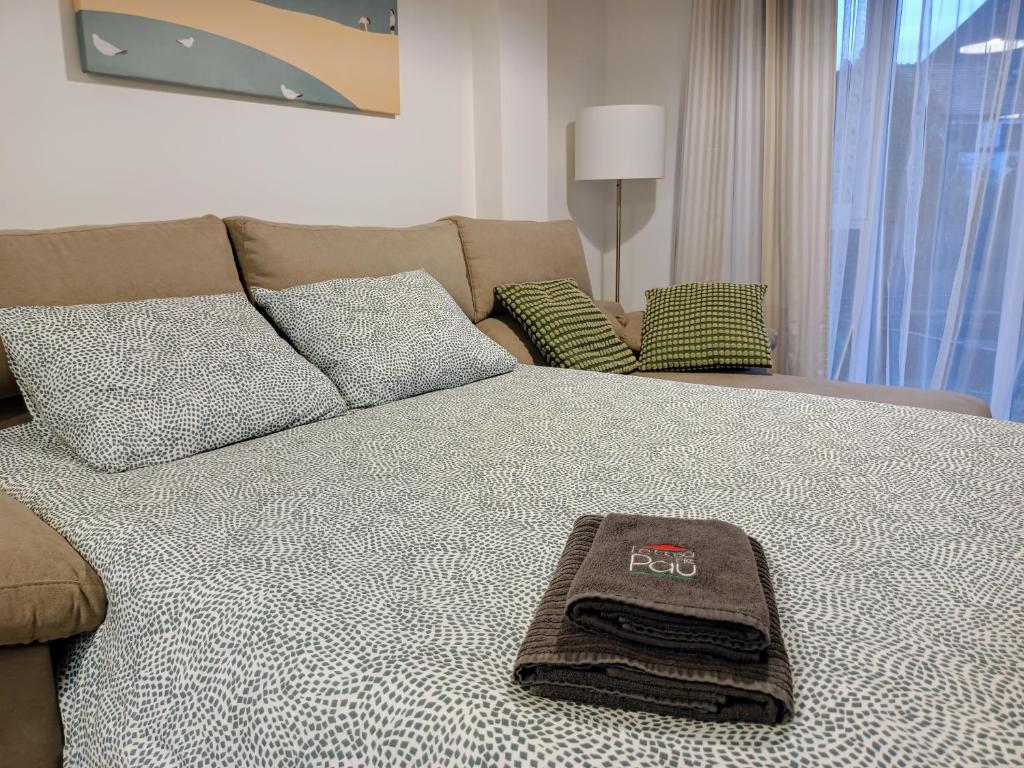 a bed with a towel on top of it at Apartamento Mar de Arousa in Ribeira