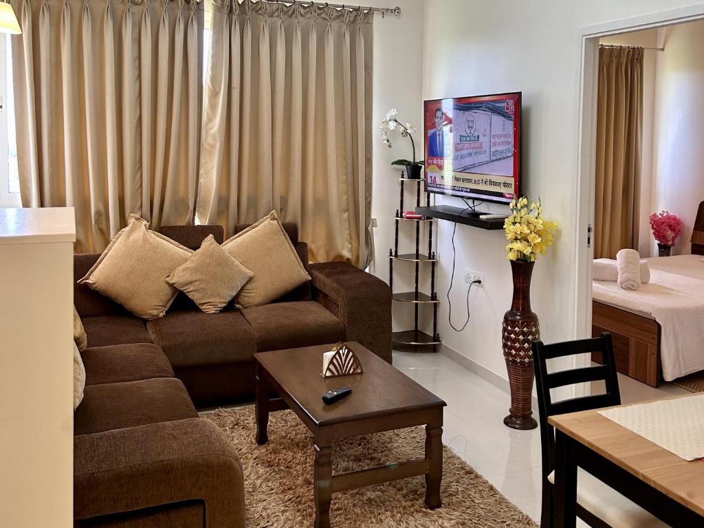 ein Wohnzimmer mit einem Sofa und einem Tisch in der Unterkunft Good Stay 1 BHK Apartment 604 in Dabolim