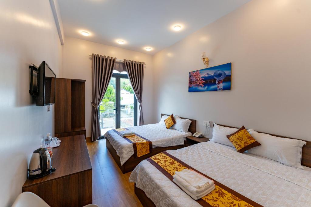 a hotel room with two beds and a tv at Hotel Mỹ Vy in Tánh Linh