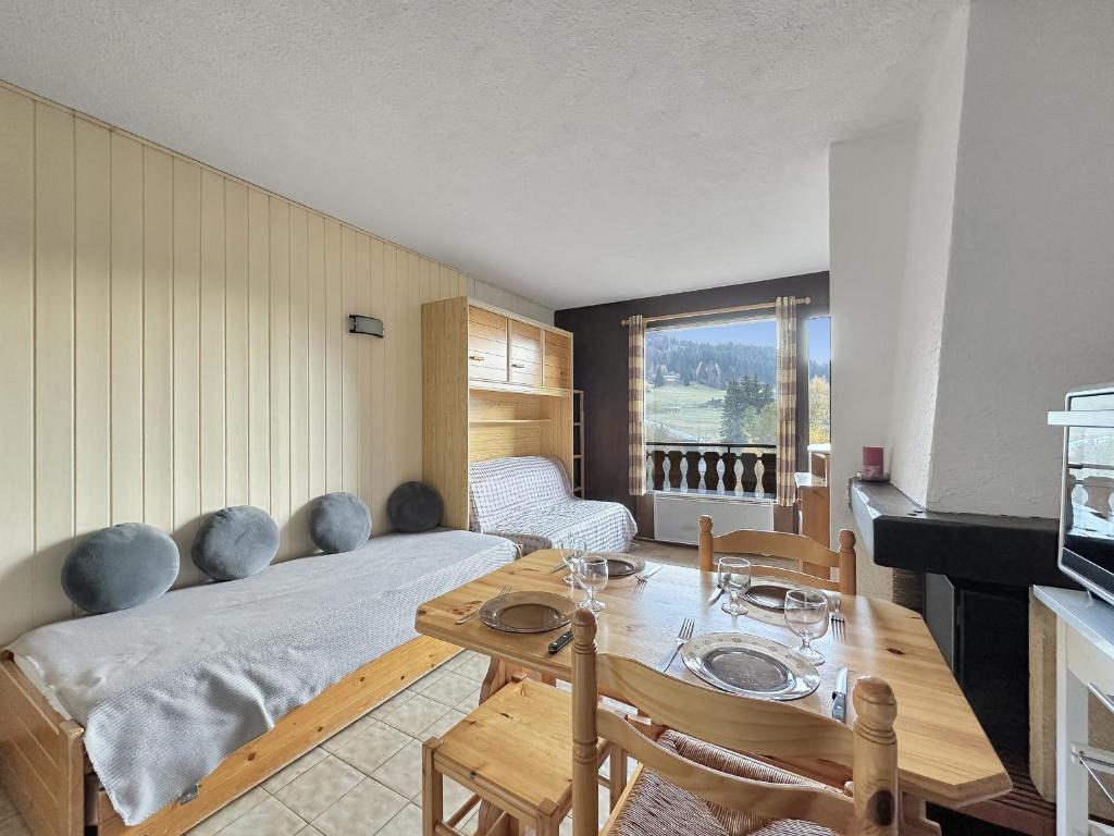 une chambre avec un lit et une table avec des chaises dans l'établissement MOU2E Studio 4 Pers centre des Carroz, aux Carroz d'Arâches