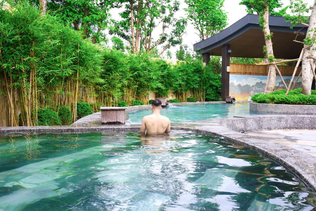 mężczyzna w basenie w ośrodku w obiekcie Miyabi Wyndham Thanh Thuỷ w mieście Phú Thọ