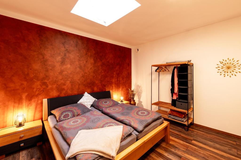 ein Schlafzimmer mit einem Bett und einer roten Wand in der Unterkunft Großzügiges Apartment im Loft-Stil in Bad Berneck im Fichtelgebirge