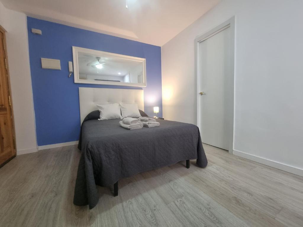 - une chambre dotée d'un lit avec un mur bleu dans l'établissement ESTUDIO en TORREMOLINOS, PLAZA DE ANDALUCIA, à Torremolinos