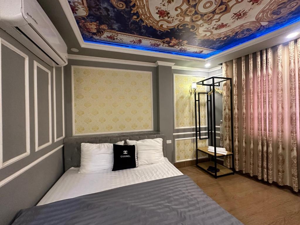 een slaapkamer met een bed met een blauw plafond bij Khách sạn Tình Yêu in Ho Chi Minh-stad