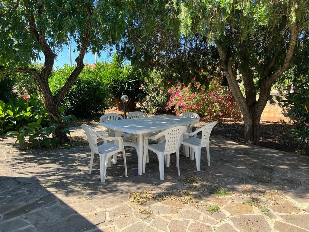 a blue table and chairs with trees and flowers at I Mandorli in Porto Conte