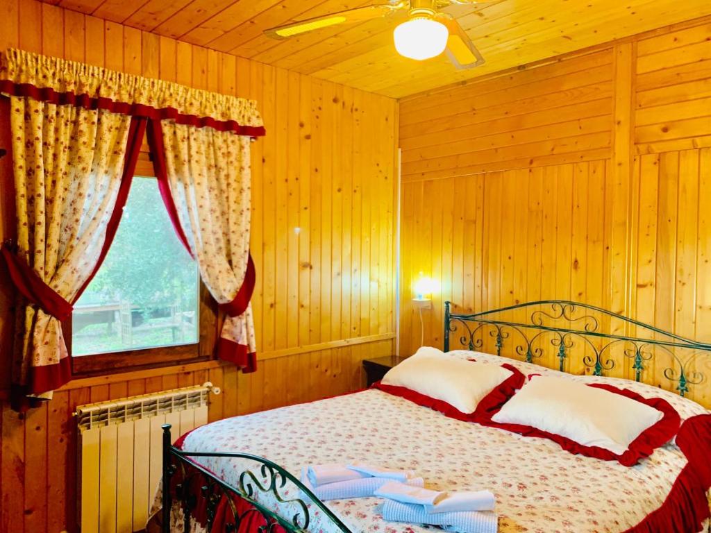 1 dormitorio con 1 cama en una habitación con paredes de madera en CicloPark Morano Calabro, en Morano Calabro