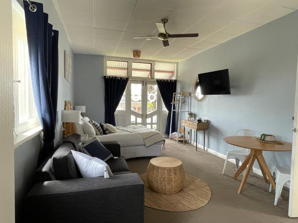una sala de estar con un sofá y una cama en Court House - Studio, en Beachport