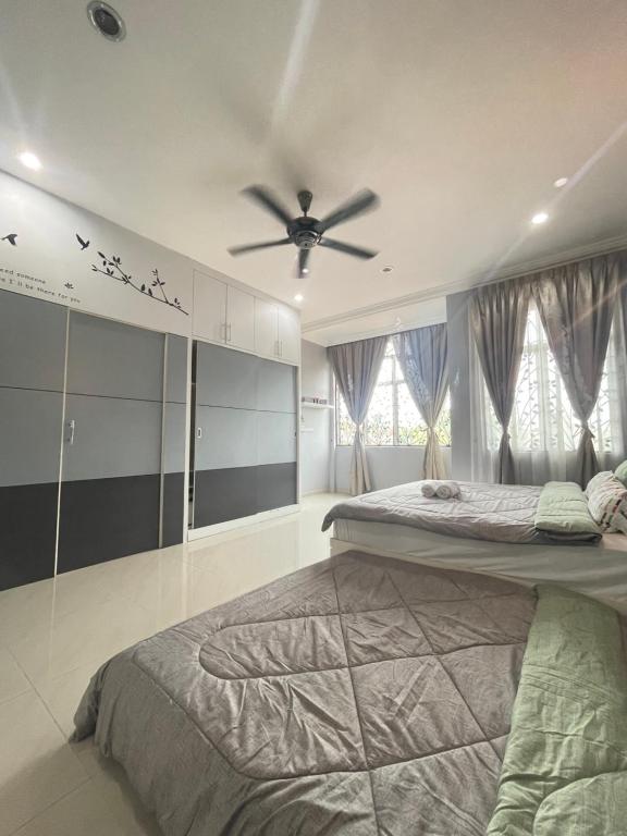 um quarto com 2 camas e uma ventoinha de tecto em Art Homestay 4 Bedrooms House by Mr Homestay em Teluk Intan