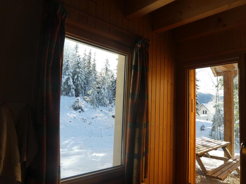 a window with a view of a snow covered yard at Chalet Beaujon Chapelle-des-Bois in Chapelle-des-Bois