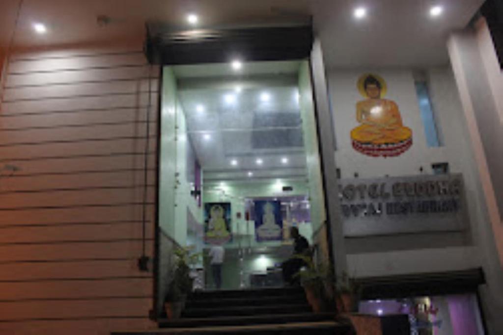un pasillo con escaleras en un edificio con una estatua en Hotel Buddha,Gaya en Bodh Gaya