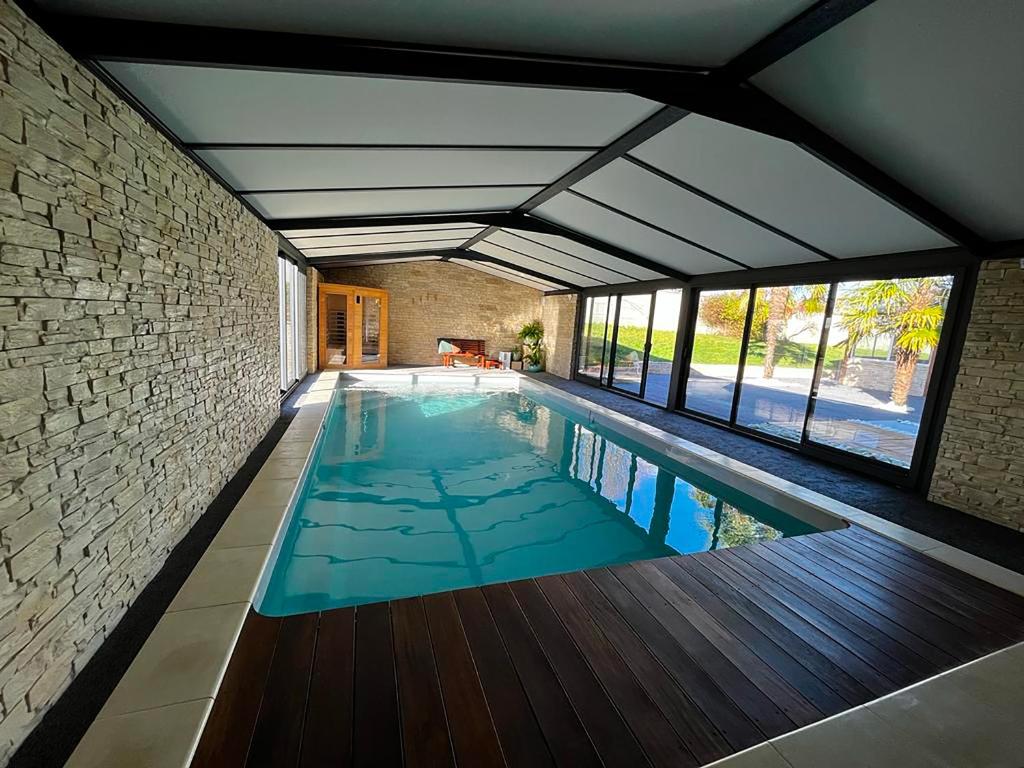 een zwembad in een huis met een bakstenen muur bij la Bastide du Laizon & Spa in Maizières