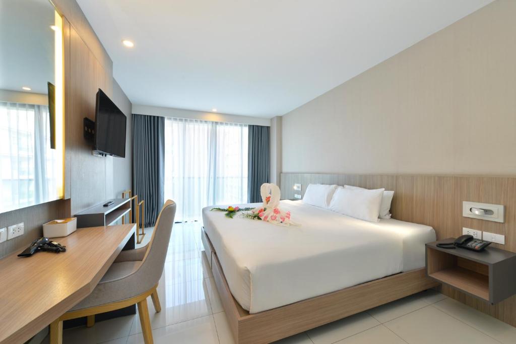 Postel nebo postele na pokoji v ubytování Grace Patong Hotel