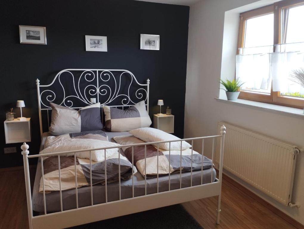 a bedroom with a bed with a wrought iron headboard at Ferienwohnung Hilderser Auszeit in Hilders