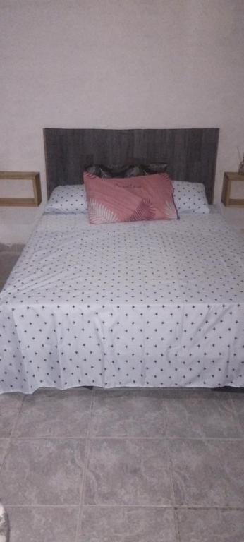 Una cama blanca grande con una almohada rosa. en Armonia un lugar para Descansar en Formosa