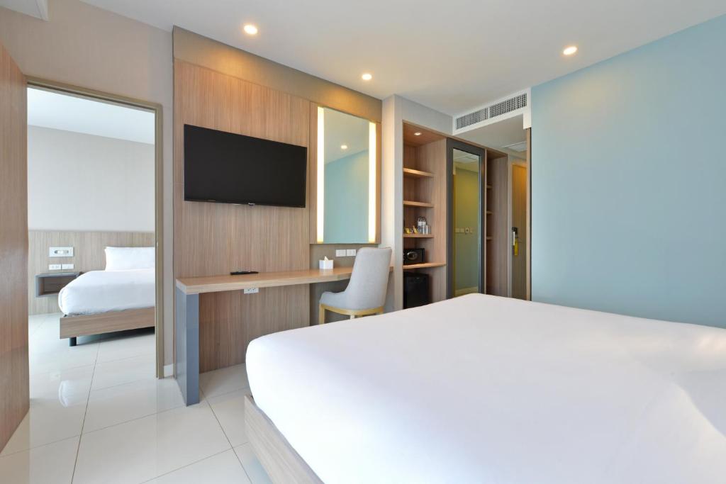 Postel nebo postele na pokoji v ubytování Grace Patong Hotel