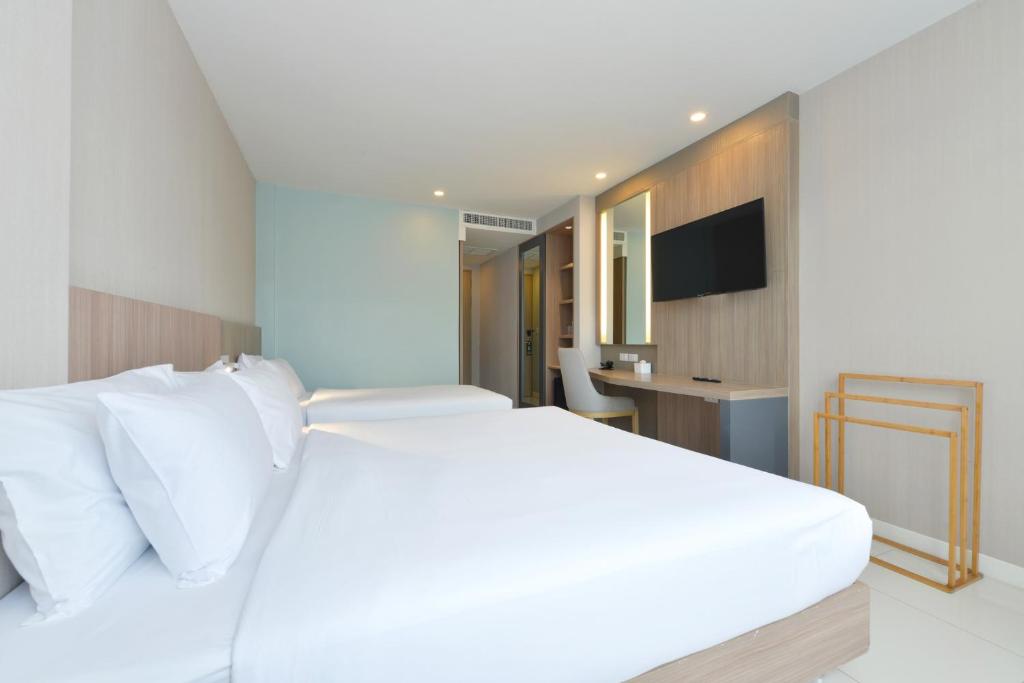 Postel nebo postele na pokoji v ubytování Grace Patong Hotel