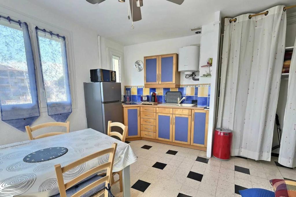 a kitchen with a table and a refrigerator at studio à 200 M de la plage in Valras-Plage