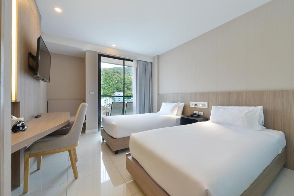 Postel nebo postele na pokoji v ubytování Grace Patong Hotel