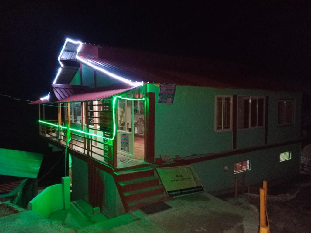 uma casa com luzes verdes à noite em The Hills County em Joshimath