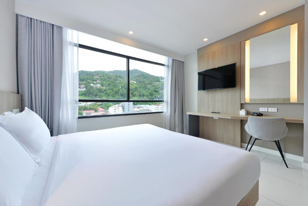 Postel nebo postele na pokoji v ubytování Grace Patong Hotel