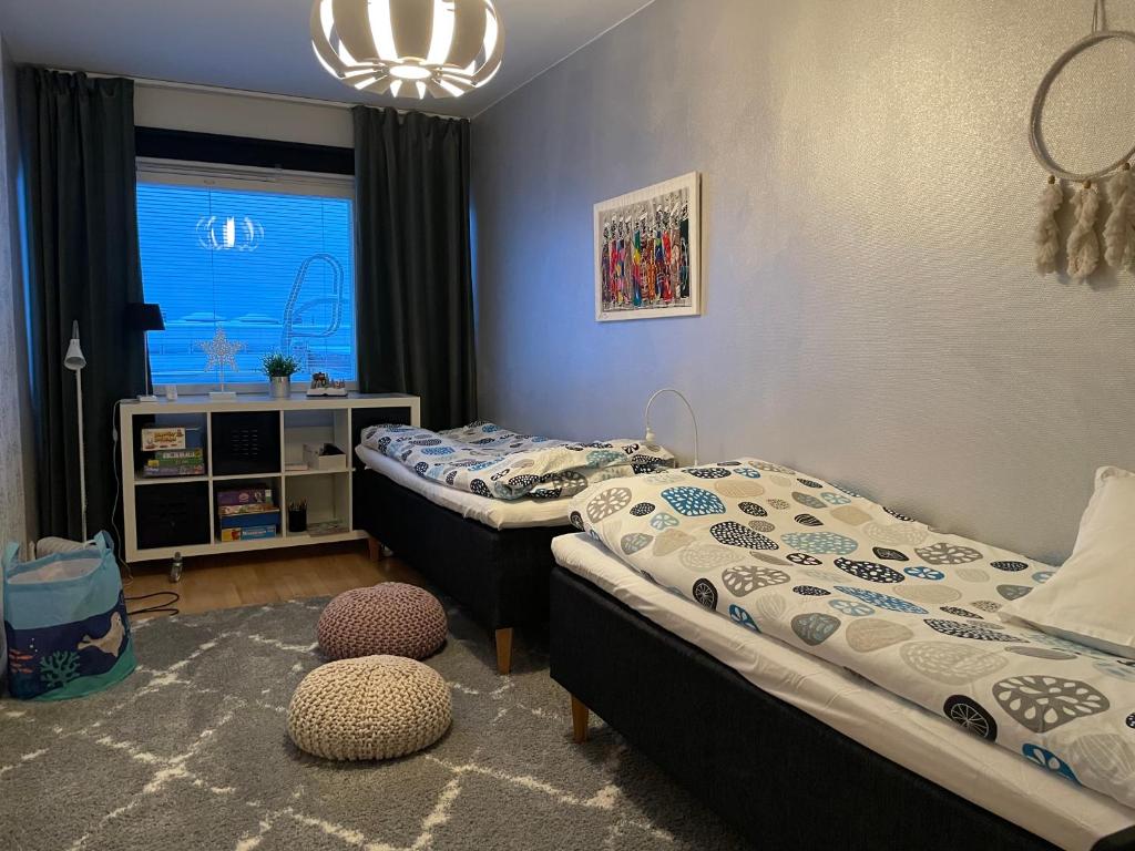 1 Schlafzimmer mit 2 Betten und einem Fenster in der Unterkunft Peaceful City Centre Apartment (2 Bdr) in Rovaniemi
