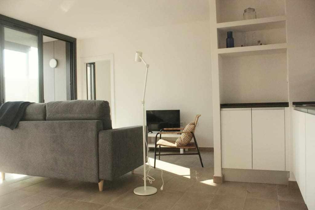 een woonkamer met een grijze bank en een stoel bij OD'A Apartaments in Roses