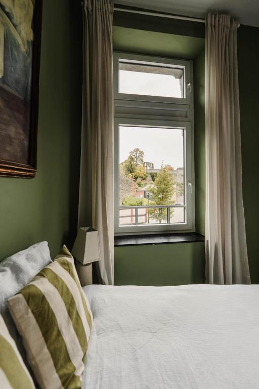 a bedroom with a bed and a window at Maison Comtale in Rochefort