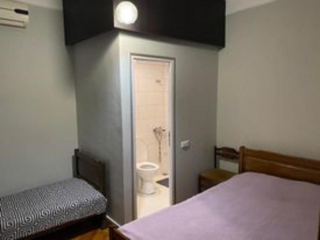 a room with a bed and a bathroom with a toilet at Mака и Сулико in Batumi