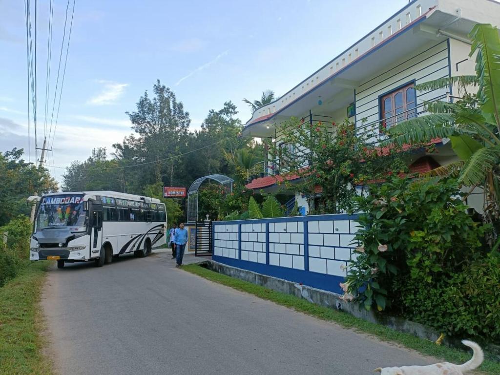 un autobús estacionado al lado de una carretera al lado de una casa en Coorg peacock feathers home stay, en Kushālnagar