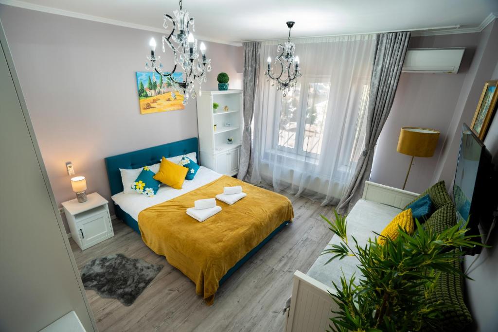 a bedroom with a bed with yellow and blue pillows at Chic Studio Old City Center - IVO19 in Bucharest