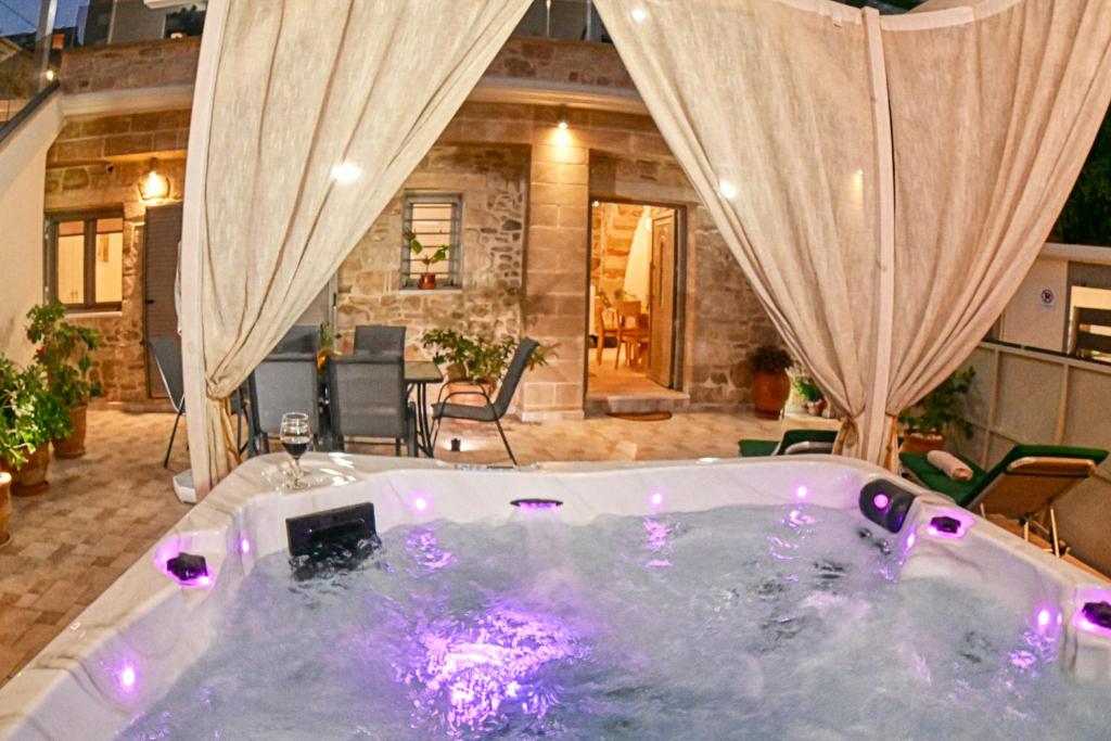 a jacuzzi tub in a living room with curtains at Petros Luxury Traditional House - Villa in Kissamos