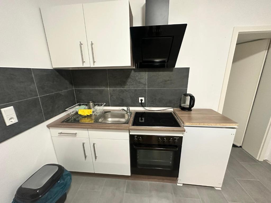 a small kitchen with a sink and a microwave at B&B Immobilien GbR in Xanten