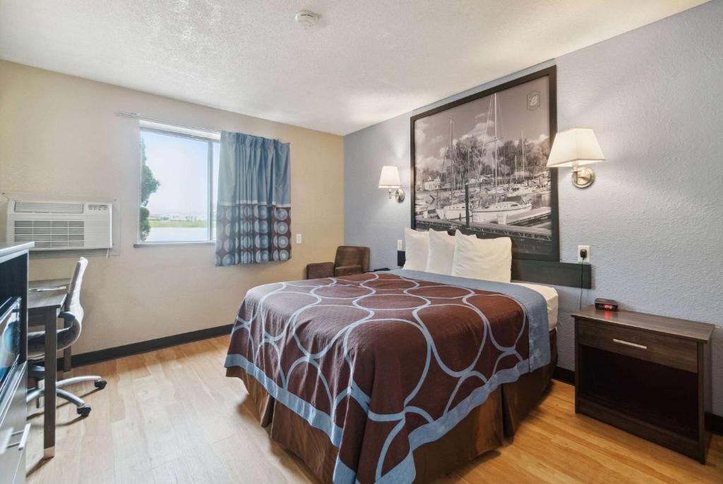 a hotel room with a bed and a desk and a window at Super 8 by Wyndham Kenosha/Pleasant Prairie in Pleasant Prairie