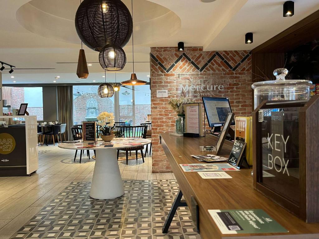 a restaurant with a table with a laptop on it at Mercure Lille Centre Vieux Lille in Lille