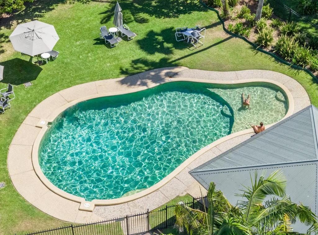una vista aérea de una piscina en un patio en Byron Lakeside Holiday Apartments, en Byron Bay