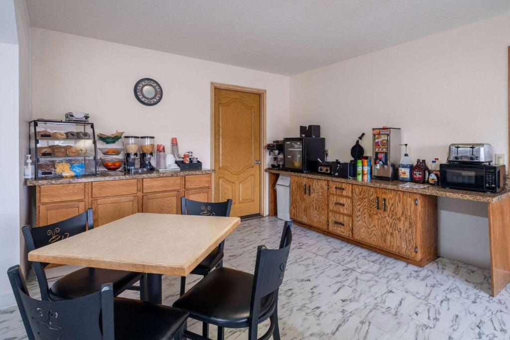 a kitchen with a table and chairs and a counter at Travelodge by Wyndham Merrill in Merrill