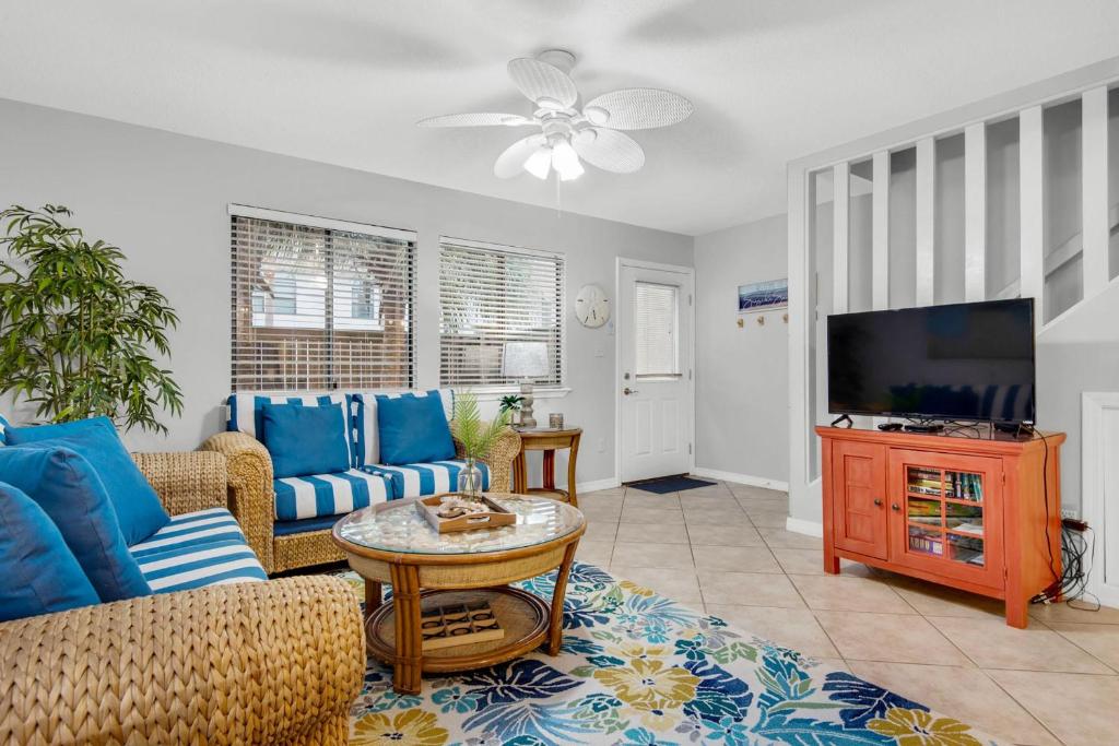 a living room with blue furniture and a flat screen tv at Sugar Beach F-26 in Navarre