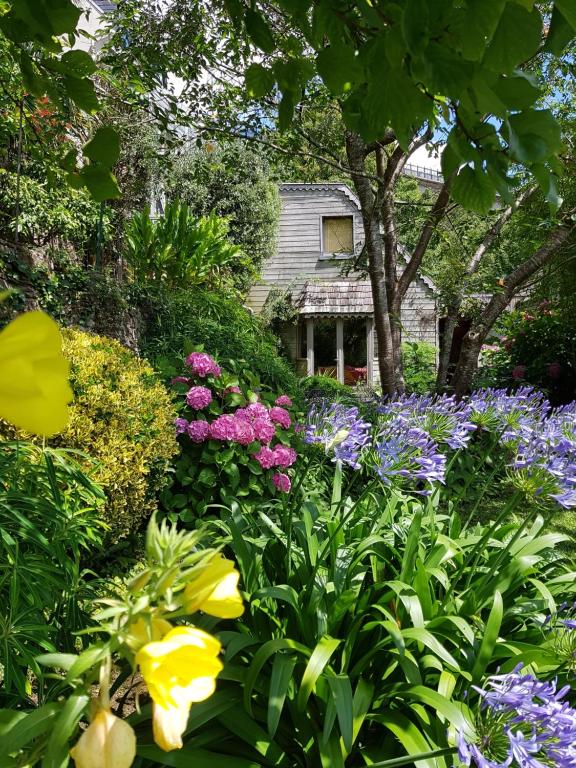 un jardin de fleurs avec une maison en arrière-plan dans l'établissement Home Sweet Home, à Brest
