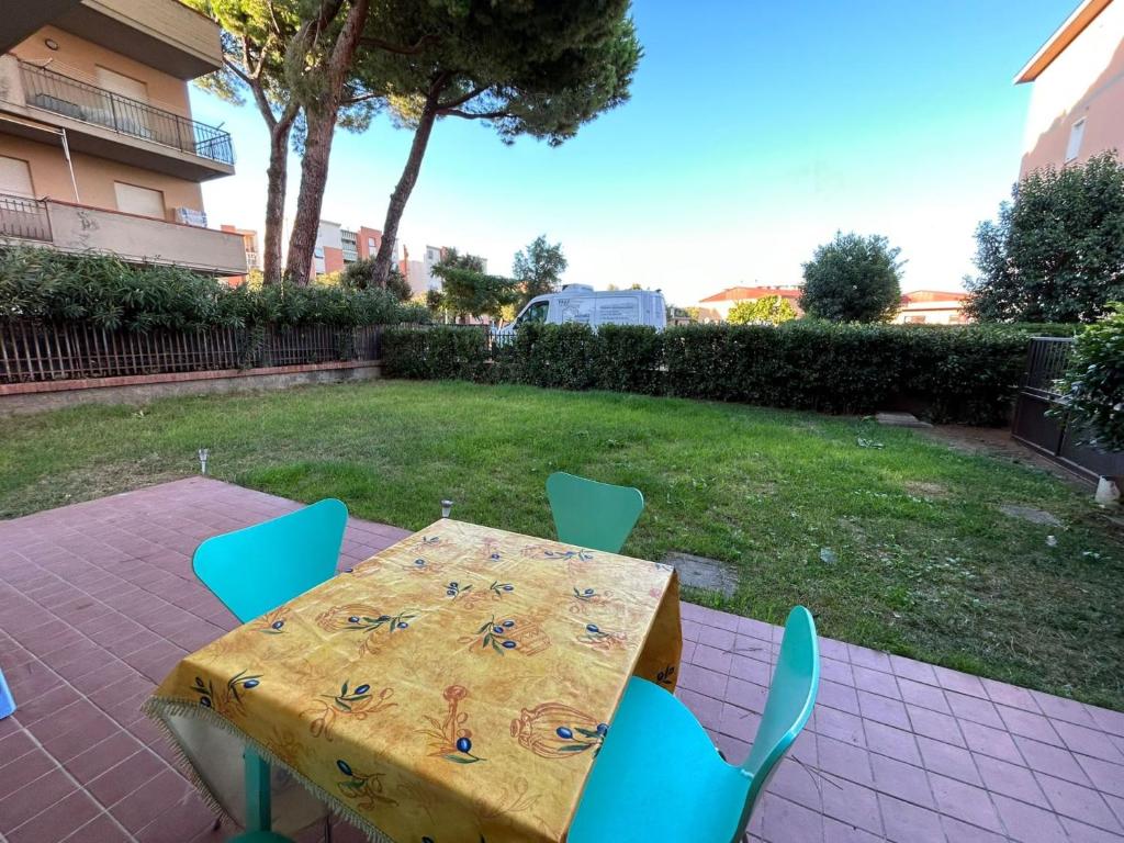 einen Tisch und Stühle auf einer Terrasse mit einem Tisch und einem Rasenplatz in der Unterkunft Casa Mare Vienna in Follonica