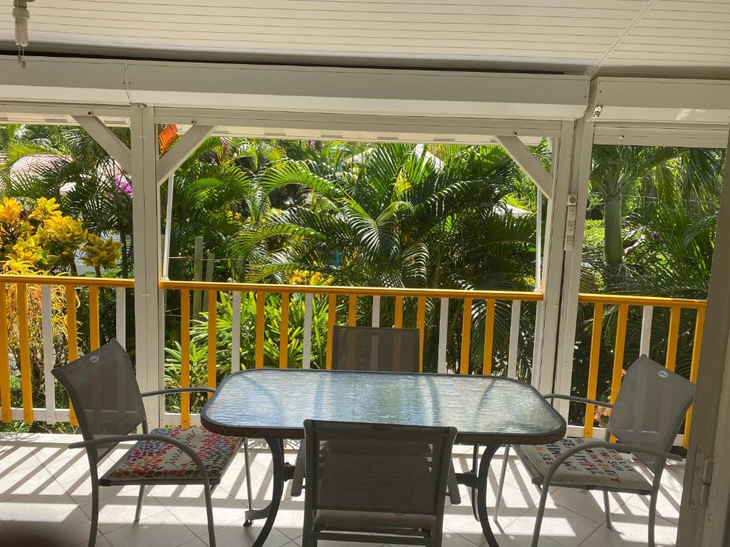 eine Terrasse mit einem Tisch und Stühlen auf einer Veranda in der Unterkunft Bungalow Belfond Plage Pointe Marin in Sainte-Anne