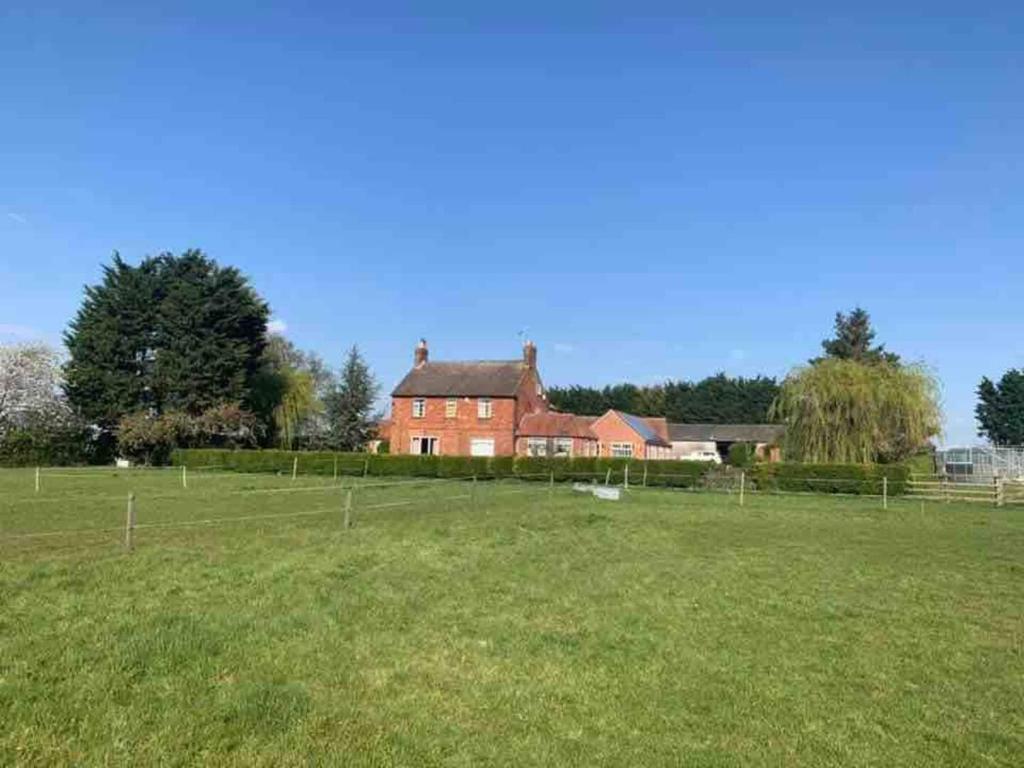 a large red house in the middle of a field at Wellbet Farm in Lincoln