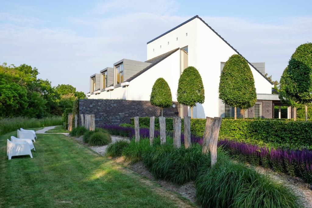 ein weißes Haus mit einem Garten mit lila Blumen in der Unterkunft Villa Zoutelande in Zoutelande