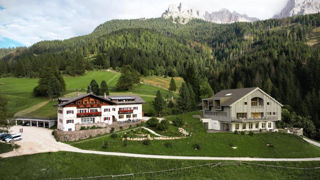 una casa grande en una colina con una montaña en Hotel Bewaller, en Obereggen