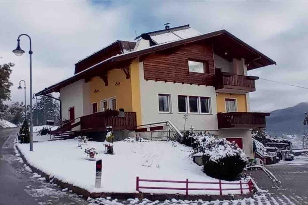 una casa con nieve en el suelo delante de ella en Casa vacanze in Val di Non en Romeno
