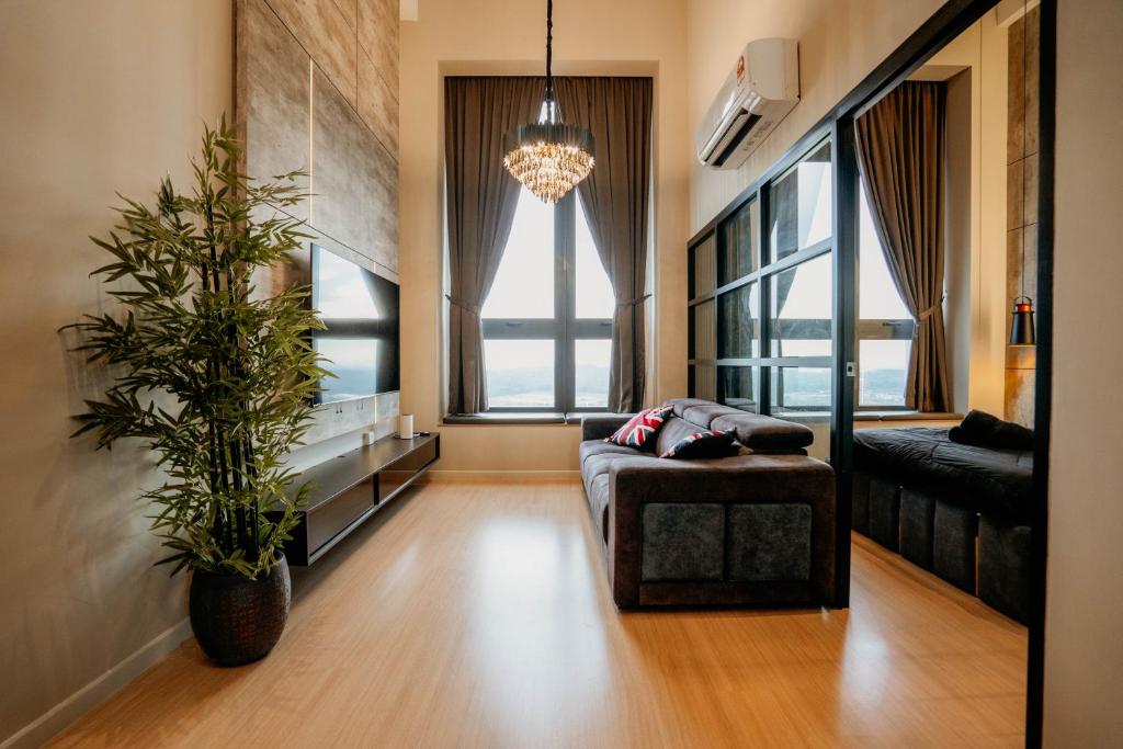 a living room with a couch and a plant at Stylish Loft Duplex Sunway Grid by Our Stay in Kampong Pendas