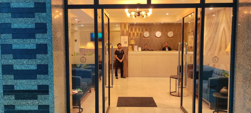 Ein Mann steht in der Lobby eines Gebäudes. in der Unterkunft Hotel Flora Inn Male Maldives in Male City