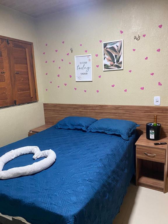 1 dormitorio con 1 cama azul y armario de madera en Temporada Serrana, en Guaramiranga