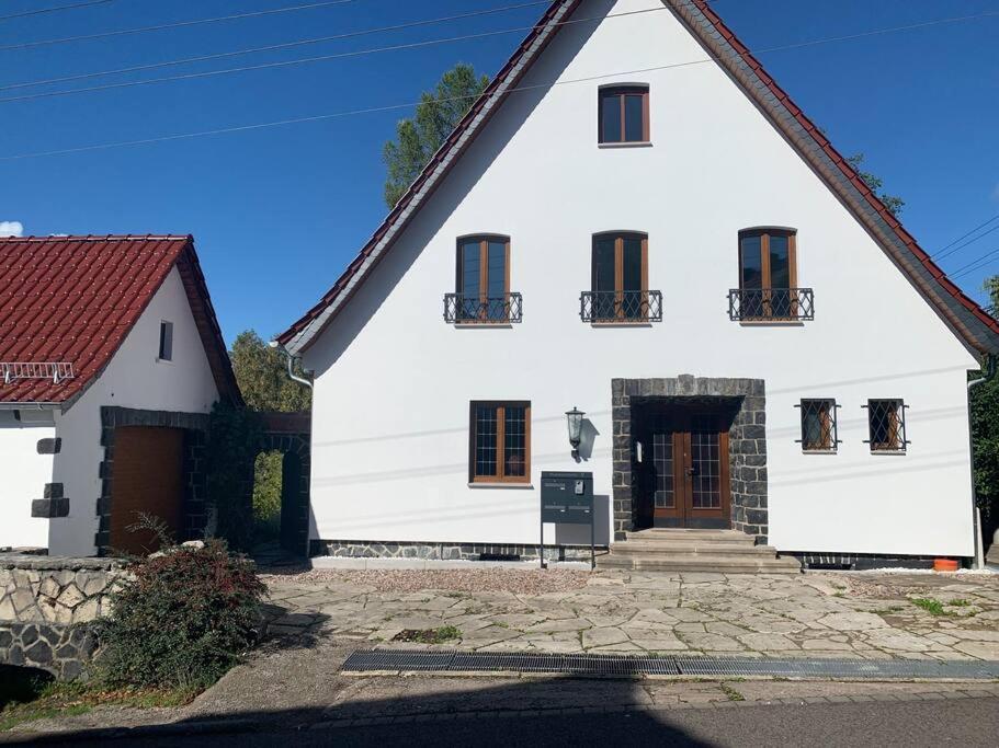 a large white house with a red roof at Schöne Ferienwohnung im Landhaus in Stadtlengsfeld