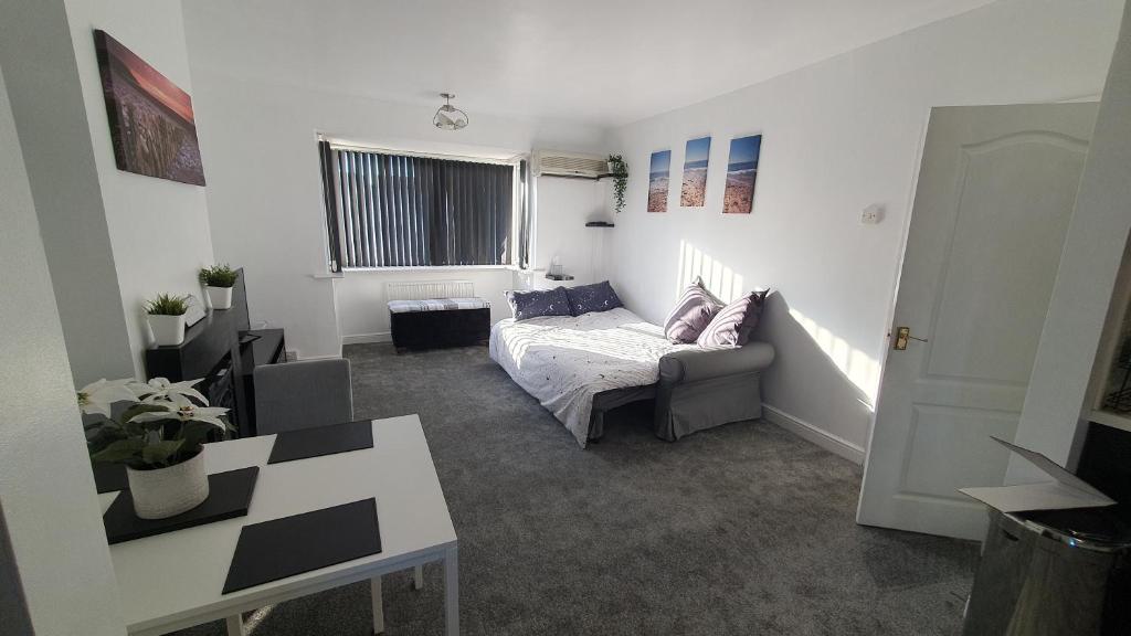 a living room with a couch and a table at Seaside 2 bed flat sleeps 6 in Lee-on-the-Solent